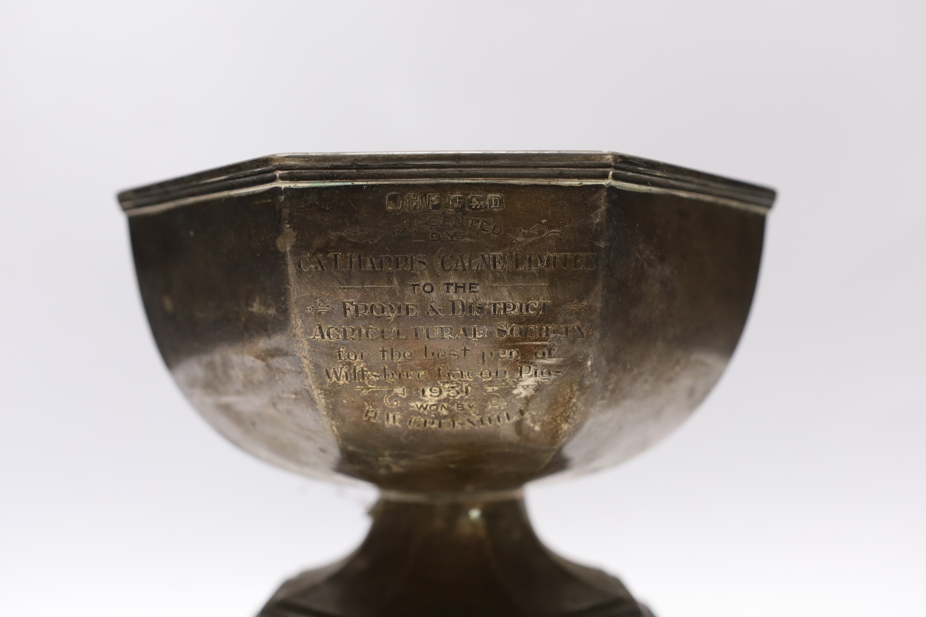 A George V silver octagonal presentation trophy bowl, John Henry Potter, Sheffield, 1930, diameter 18.2cm, 17oz, on an ebonised plinth base.